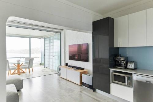 a living room with a kitchen and a dining room at Tamarama Beachfront Apartment on Bondi to Bronte Walk in Sydney