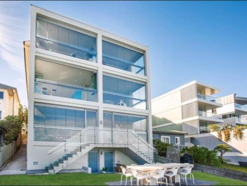 a large building with a staircase in front of it at Tamarama Beachfront Apartment on Bondi to Bronte Walk in Sydney
