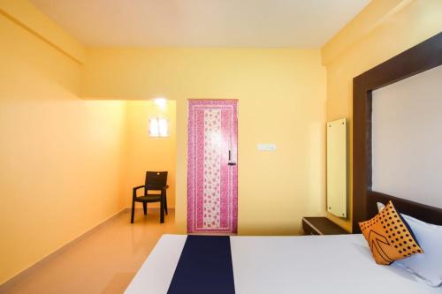 a bedroom with a bed and a door with a pink curtain at HOTEL KK BHAWBAN 1IN PURI in Puri