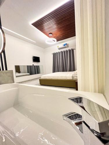 a bathroom with a tub and a bedroom with a bed at K-Road in Phnom Penh