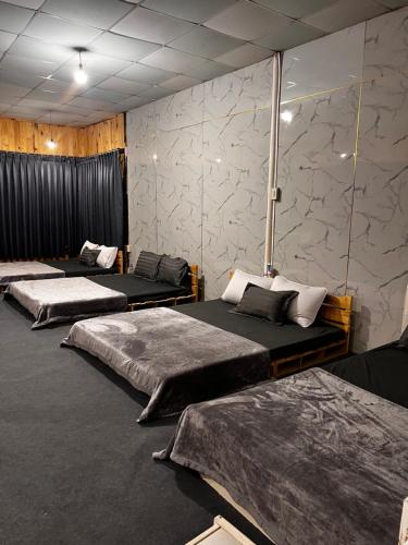 Di LinhにあるGarden Homestayのベッド3台が備わる壁の客室です。