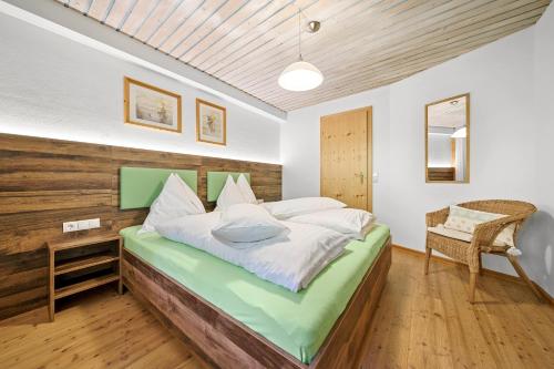 sypialnia z dużym łóżkiem z drewnianym zagłówkiem w obiekcie Appartement Ferienhof Ortnergut w mieście Eben im Pongau
