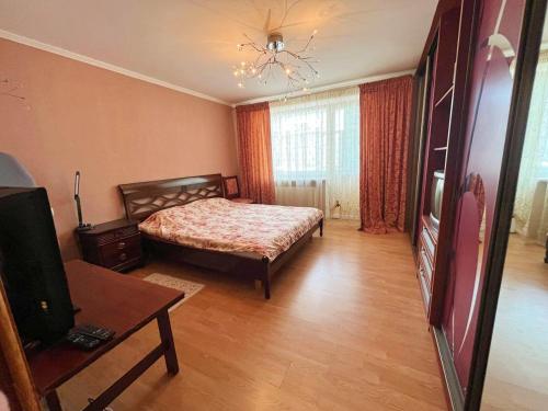 1 dormitorio con 1 cama y TV en Тимирязева 47А, en Kropyvnytskyi