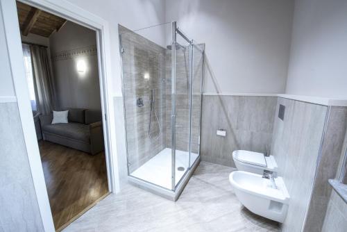 a bathroom with a shower and a toilet and a sink at Hotel Sesmones in Lodi