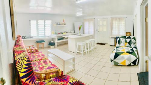 a living room with a couch and a kitchen at Tonga Cottage - Triple Room with Shared Facilities in Folaha