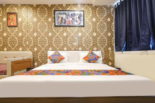 a bedroom with a bed and a wall at FabHotel Prithviraj in Indore