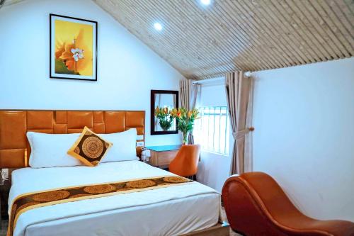 a bedroom with a bed and a chair and a window at GRAD Queen Hotel 2 - Hà Đông in Hanoi