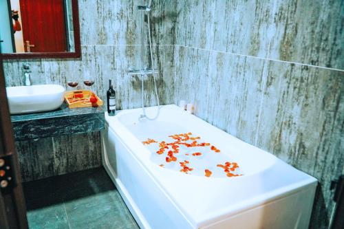 a bathroom with a bath tub with flowers on it at GRAD Queen Hotel 2 - Hà Đông in Hanoi