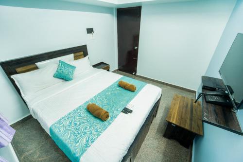 Jeyam Residency في بونديتْشيري: غرفة نوم مع سرير مع وسادتين بنية اللون