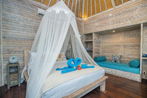 a bedroom with a bed with a blue teddy bear on it at Nusa View in Nusa Lembongan