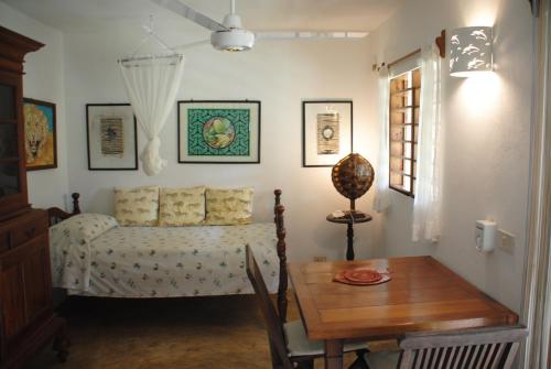a bedroom with a bed and a wooden table at Villa Palissandre in Nosy Be