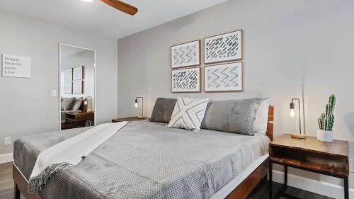 a white bedroom with a large bed and a mirror at Beautiful newly remodeled 2-Bdrm Biltmore Condo in Phoenix