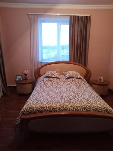 a bedroom with a bed with a large window at Family house in Sevan