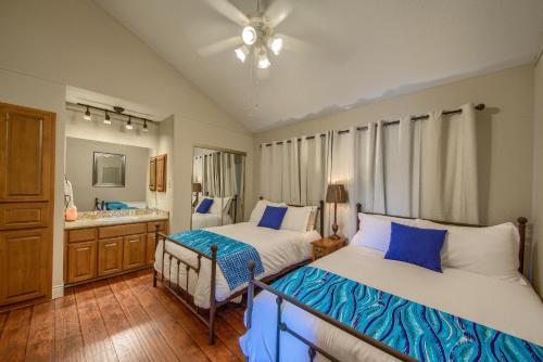 een slaapkamer met 2 bedden en een badkamer met een wastafel bij River Zen CW C207 in New Braunfels