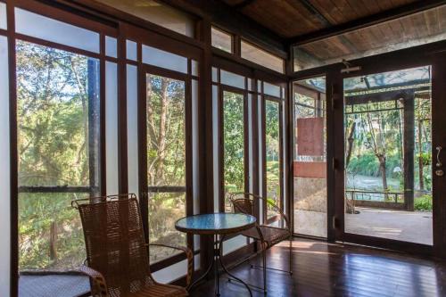 a room with a table and chairs and windows at Siyuan Ju Homestay in Puli