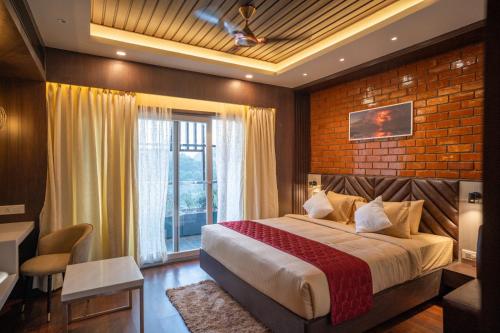 1 dormitorio con cama y pared de ladrillo en HOTEL BLUE REGENT, en Port Blair