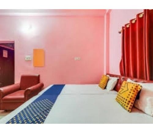 a bedroom with a large bed and a chair at Hotel Pratima And Banquet Hall, Muzaffarpur in Muzaffarpur