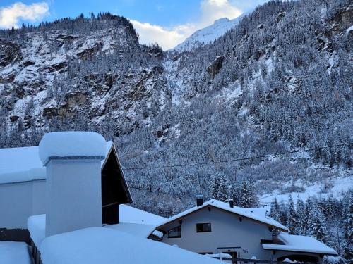 a snow covered mountain with a house in the foreground at Apartment in Pitztal near Ski Glacier in Oberlehn
