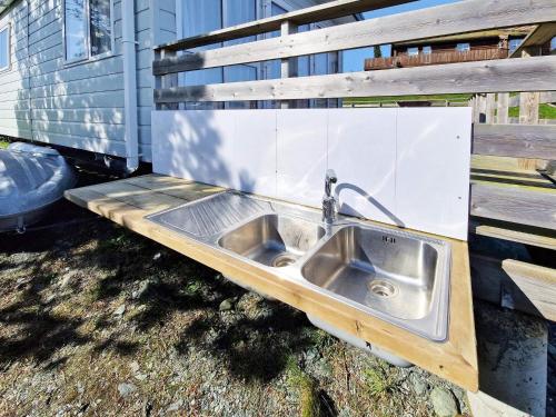 a kitchen sink attached to a wooden fence at 6 person holiday home in Tansøy-By Traum in Tansøy
