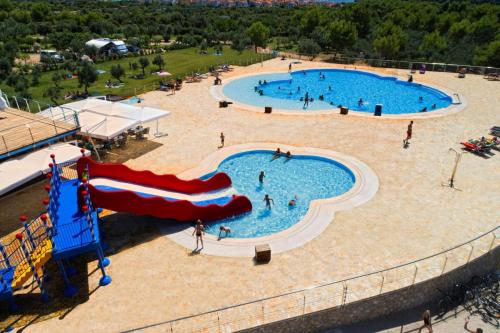 an overhead view of a large swimming pool with a slide at Mobile Homes Kovacine Cres - CIN02100d-MYA in Cres
