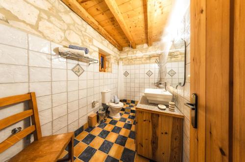 a bathroom with a toilet and a sink at Joanna's Stone Villas in Vasilikos