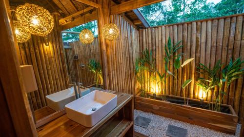 a bathroom with a sink and a toilet and a window at Barya Lang Villa- Native villa with jeepney room in El Nido