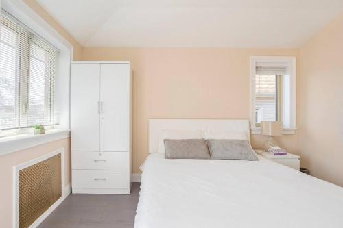 a white bedroom with a large bed and windows at cozy private room 2 in flushing in Flushing