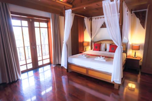 a bedroom with a bed with a canopy at Classic Thai style Cozy Villa pool garden in Patong Beach