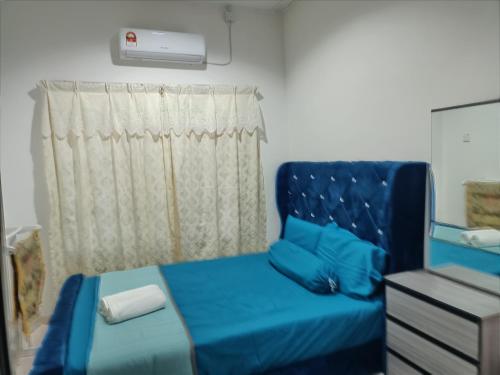 a bedroom with a blue chair and a window at Leeza Homestay in Kampung Kempadang