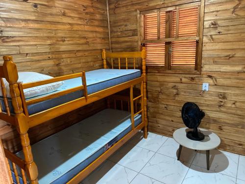 a bedroom with two bunk beds in a cabin at Chalés confortáveis in Rio Grande