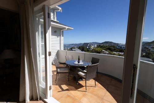 a patio with a table and chairs on a balcony at Khandallah Harbour View BnB in Wellington
