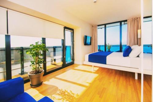 a bedroom with a bed and a large window at ORBI CITY - Central Apartment in Batumi