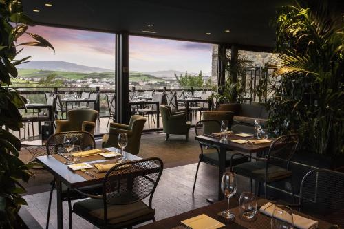 a restaurant with tables and chairs and a view at Hotel Castillo de Gorraiz&Spa in Gorraiz