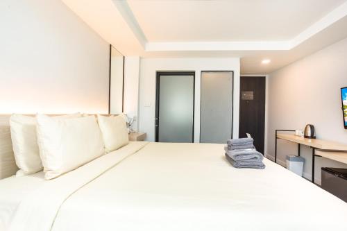 a white bed with a pair of shoes sitting on it at ISTY Design Hotel in Chiang Mai