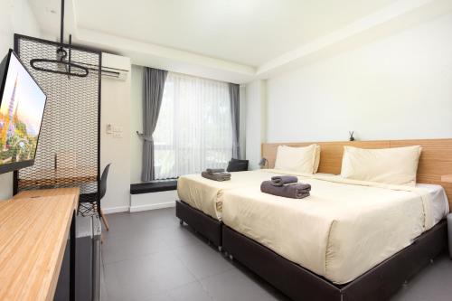 a bedroom with a large bed and a television at ISTY Design Hotel in Chiang Mai