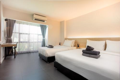 een hotelkamer met 2 bedden en een raam bij ISTY Hotel -SHA Extra Plus in Chiang Mai