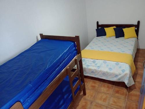 twee bedden naast elkaar in een kamer bij Apartamento Pé Na Areia in Mongaguá