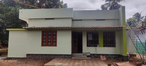 uma pequena casa branca com uma porta em Beun Residency em Nagercoil