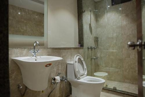 a bathroom with a toilet and a sink and a shower at Hotel The Shiv Regency in Gandhidham