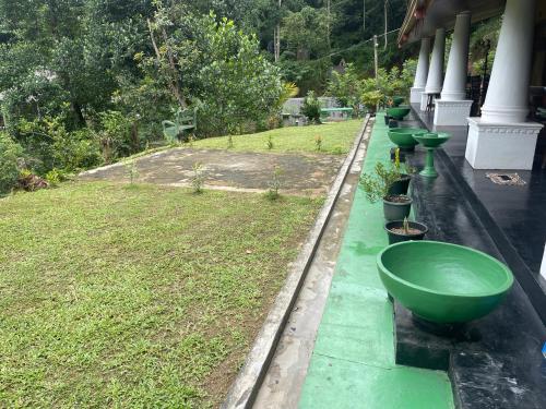 a row of green sinks on the side of a building at Eagles Eco Lodge - Kandy in Digana