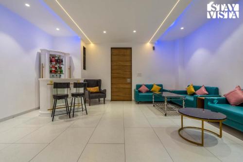 a living room with a blue couch and a bar at Richmond House by VEO - Part of StayVista in Aurangabad