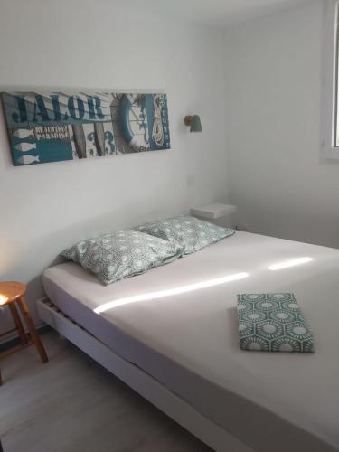 - un lit dans une chambre avec une photo sur le mur dans l'établissement Maisonnette à deux pas de la plage dans résidence calme, à La Tranche-sur-Mer