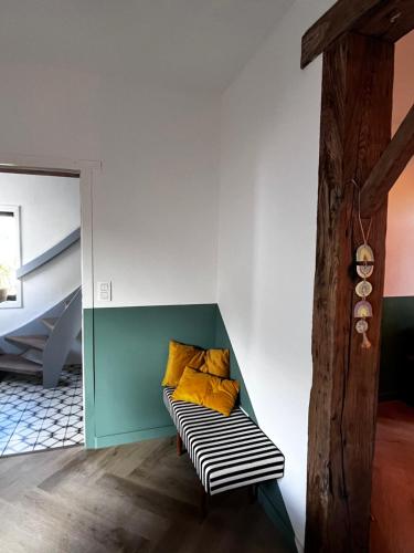una habitación con un banco con almohadas amarillas. en De Koer Kanne, en Kanne