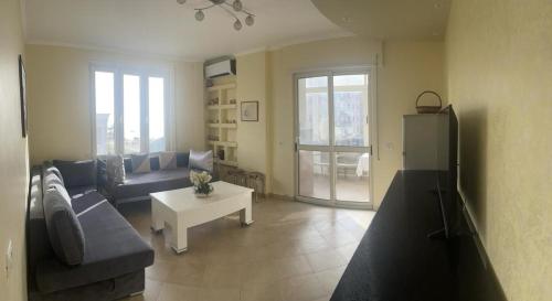 een woonkamer met een bank en een tafel bij MILA'S BEACH APARTMENT in Durrës