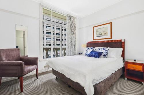 a bedroom with a bed and a chair and a window at Rendezvous Hotel-like City View 1b1b Apt in CBD in Brisbane