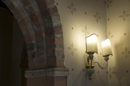 a light on a wall next to a brick wall at Hotel Sesmones in Lodi