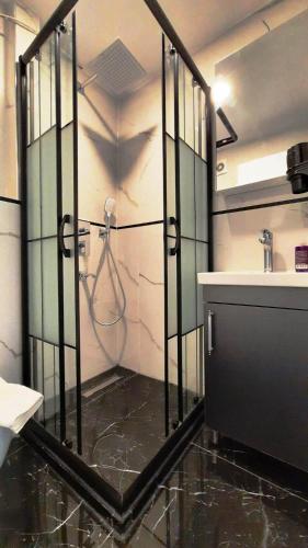 La salle de bains est pourvue d'une douche, d'un lavabo et d'un miroir. dans l'établissement SAND DOOR HOTEL, à Istanbul