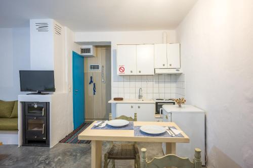 eine kleine Küche mit einem Tisch und eine kleine Küche mit einem Kühlschrank in der Unterkunft Γκαρσονιέρα #1 in Iraklio