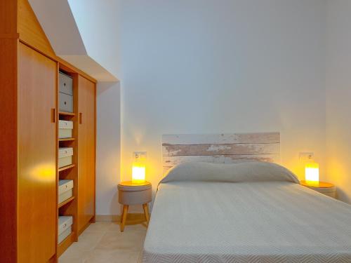 1 dormitorio con 1 cama y 2 luces en 2 mesas en Vivalidays Angels - Blanes - Costa Brava, en Blanes