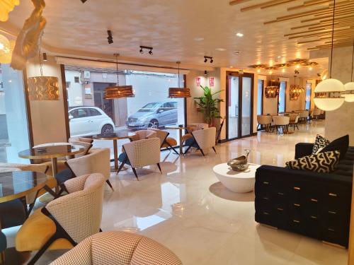 una hall con tavoli e sedie in un edificio di Hotel Suites Moma Centro a Villanueva de la Serena